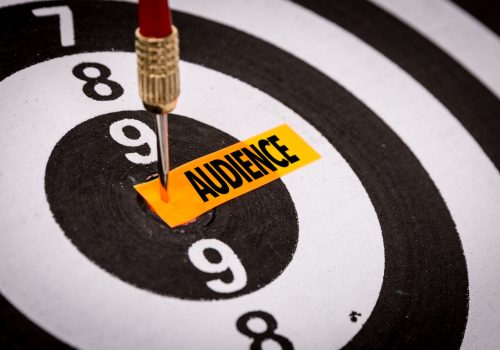 A dart board with a dart hitting the bullseye that says Audience