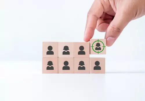 A person picking one individual block over the others, representing how personalized content marketing works to target the individual